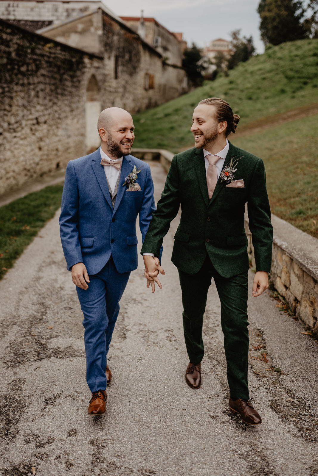 2 Männer heiraten und gehen Hand in Hand vor ihrer Hochzeitsfotografin. Diese hält diese ganz besonderen Momente in natürlichen Erinnerungen in Wien und Niederösterreich fest.