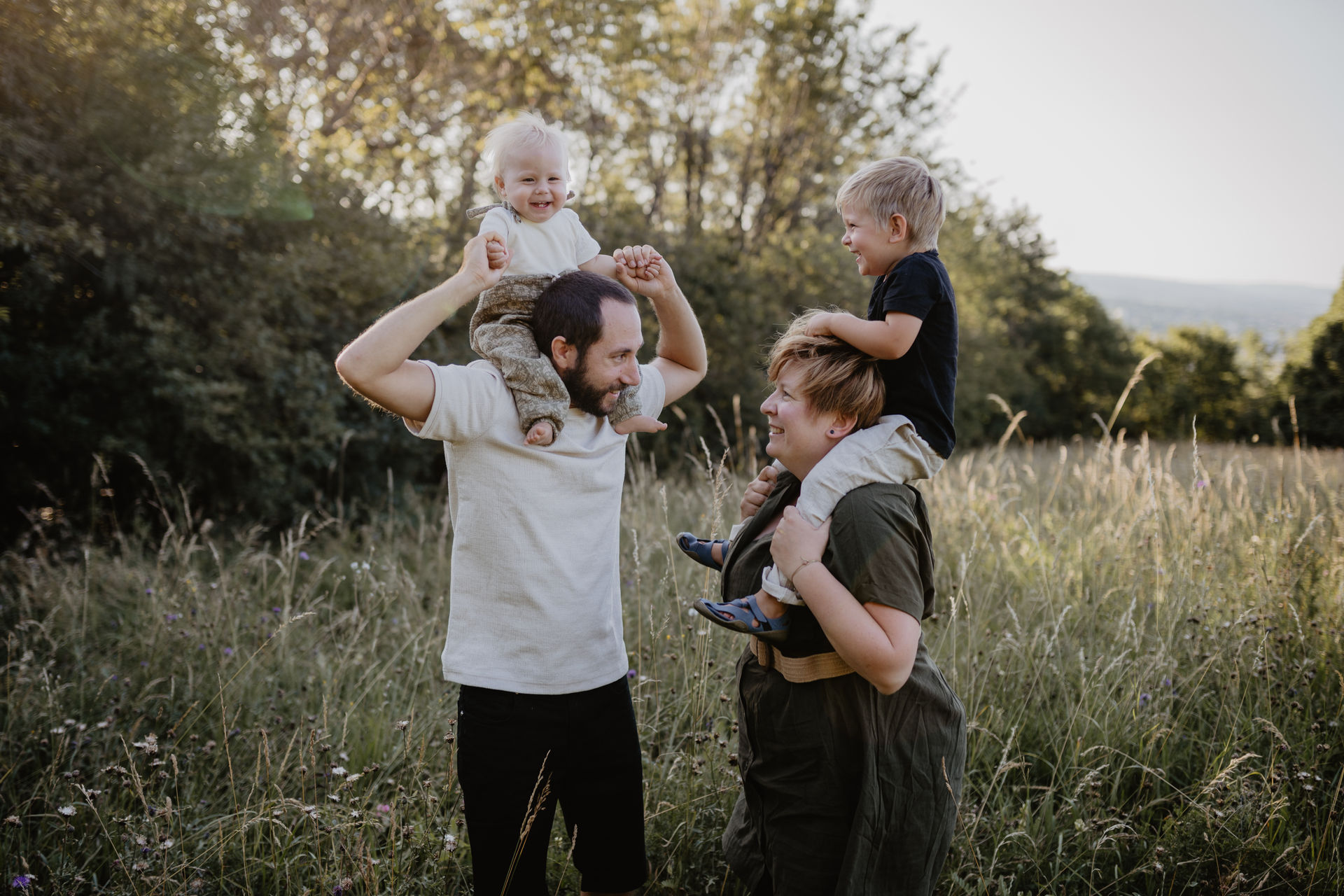 In Mödling schaffen wir Familienfotos in der Natur, die Kinder sitzen auf den Schultern und alle Lachen.